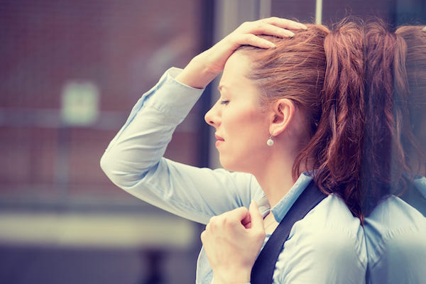 woman holding her head in distress